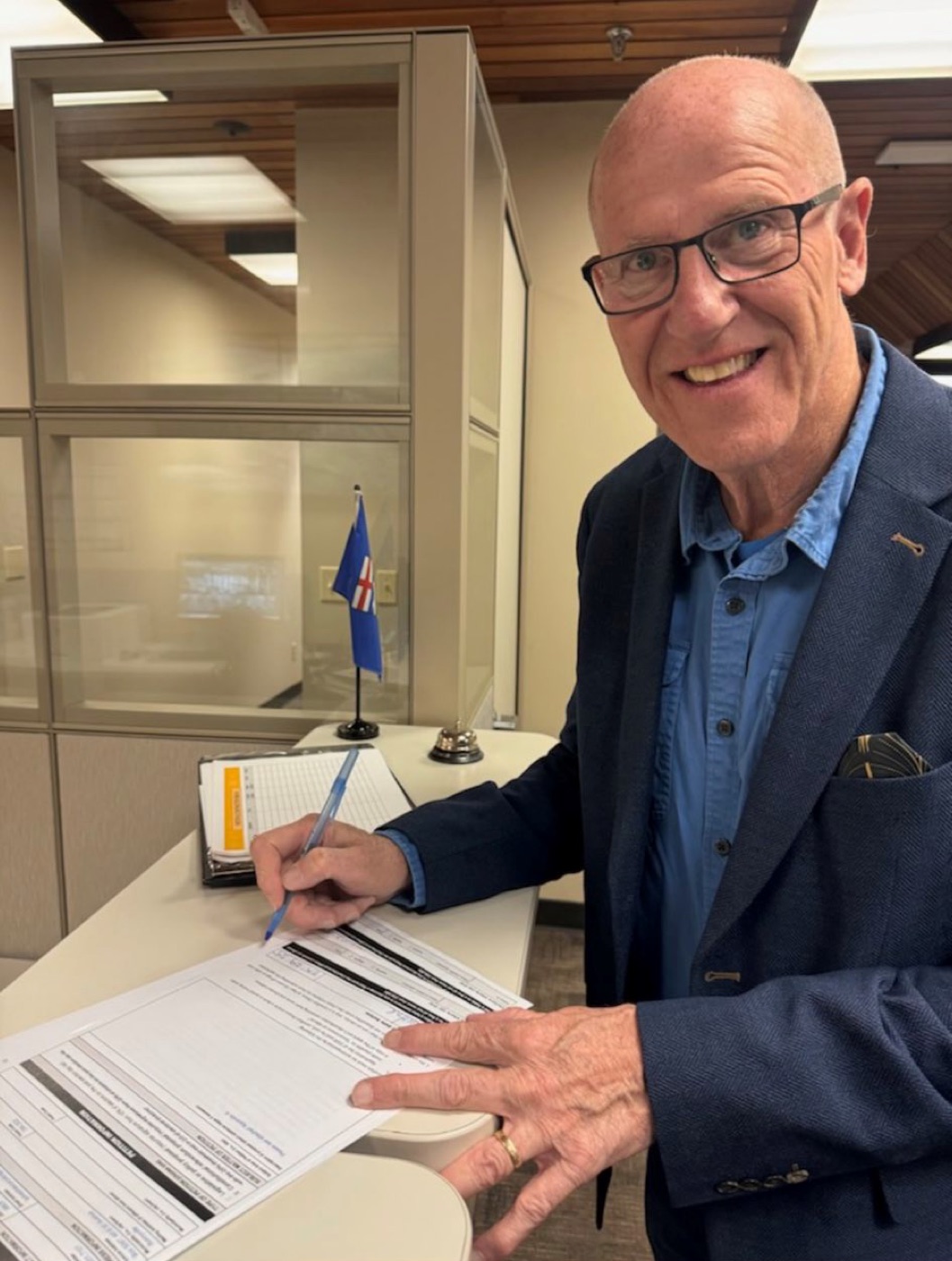 Mitch Sylvestre signing the citizen initiative application at Elections Alberta