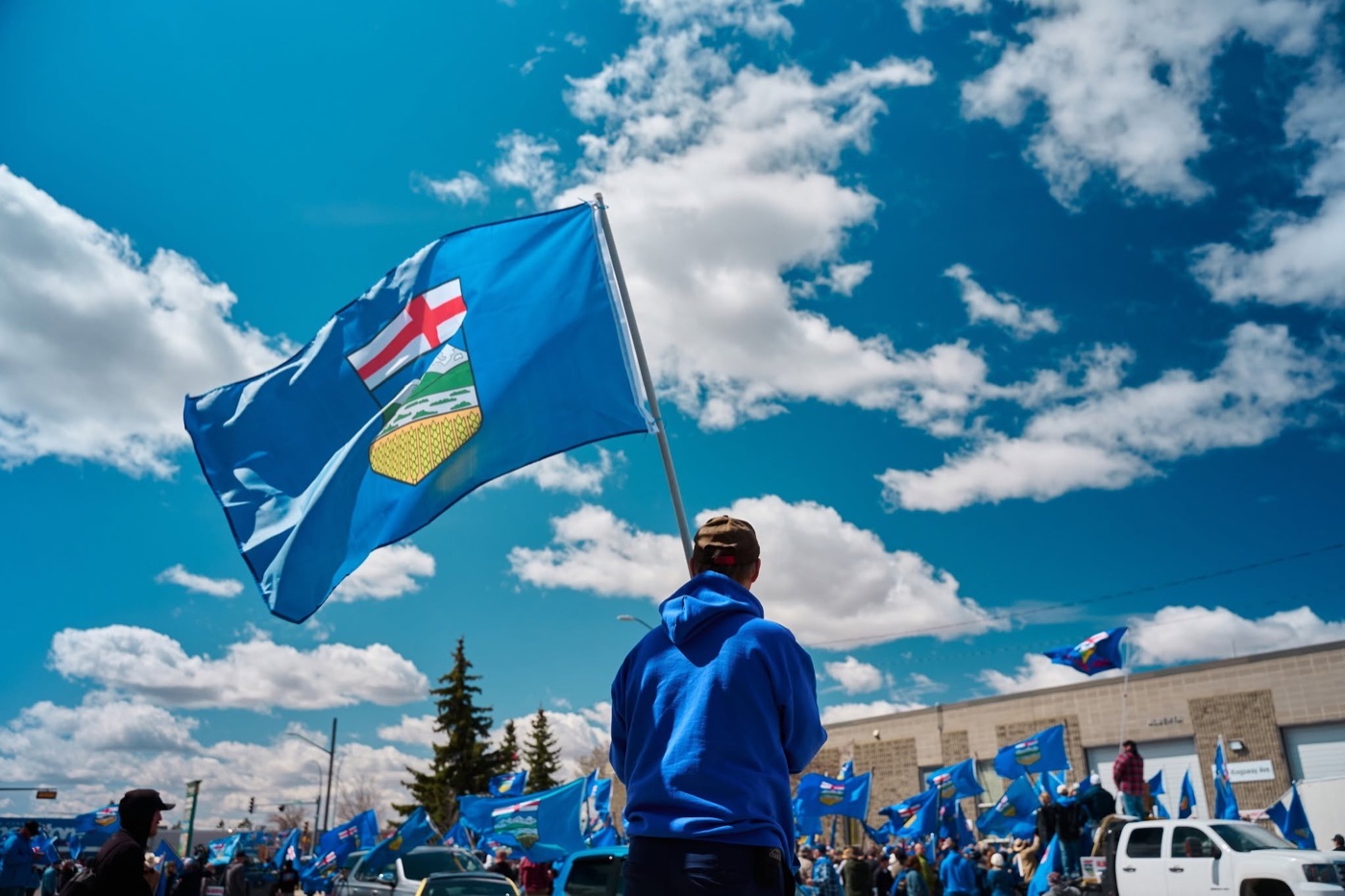 Supporter flying the Alberta flag at the delivery rally