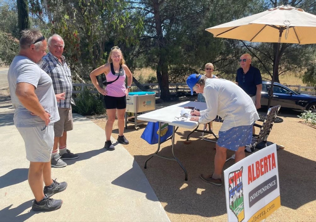 Albertans signing the petition at a table in California