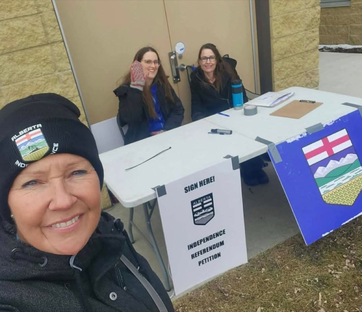 Volunteers at a Sign Here petition table